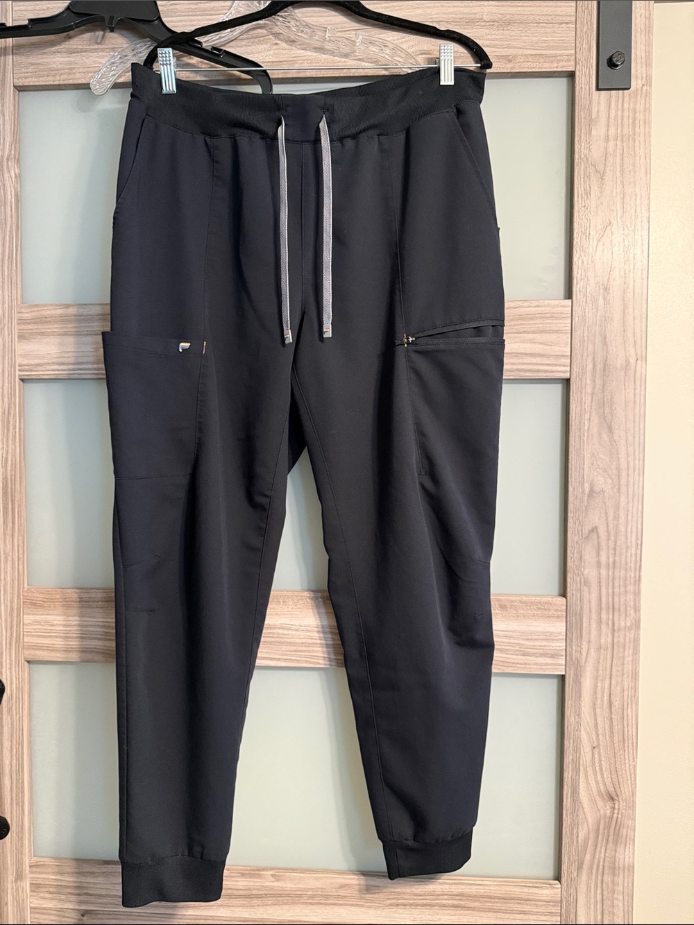 Fabletics Pride Black Cargo Scrub Joggers with Gray and Rainbow Drawstrings.